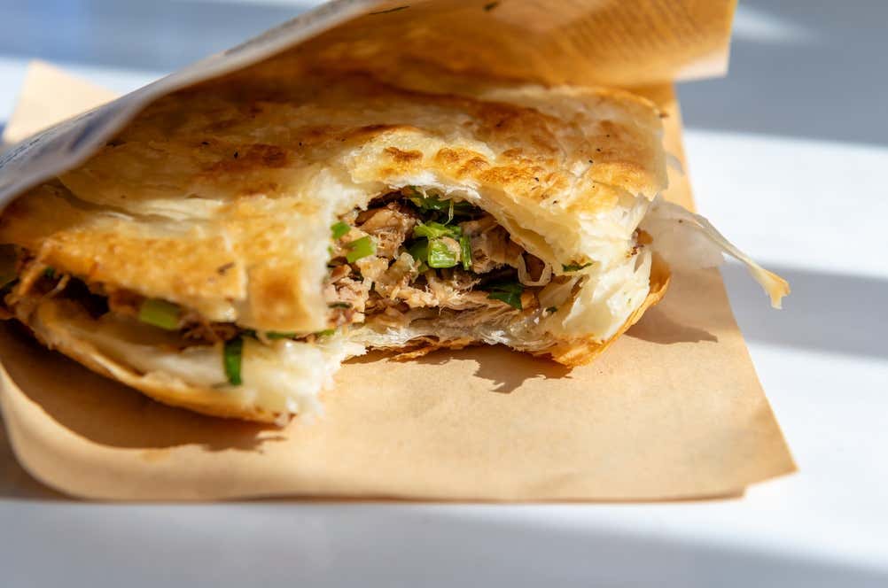 Roujiamo, tradicional sanduíche da culinária chinesa, preparado com pão achatado de casca crocante e recheado com carne de porco