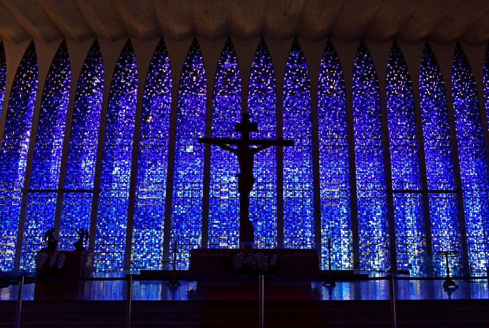 Silhueta de Jesus na cruz diante dos vitrais em tons de azul do Santuário Dom Bosco, um dos mais belos templos religiosos de Brasília, no Distrito Federal, Brasil