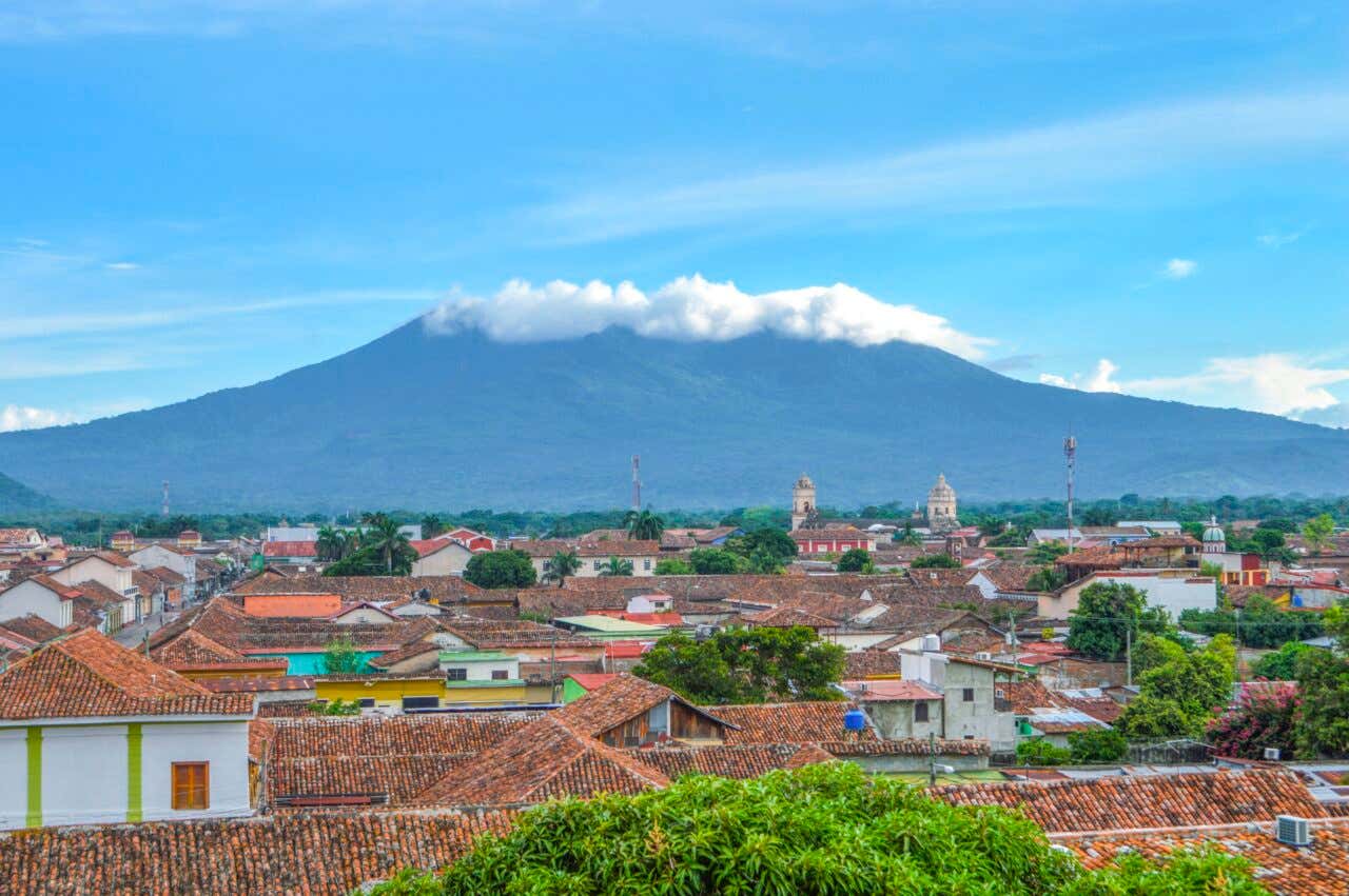 Vista del volcán Mombacho con nubes en la cima sobre los tejados rojos de la ciudad de Granada