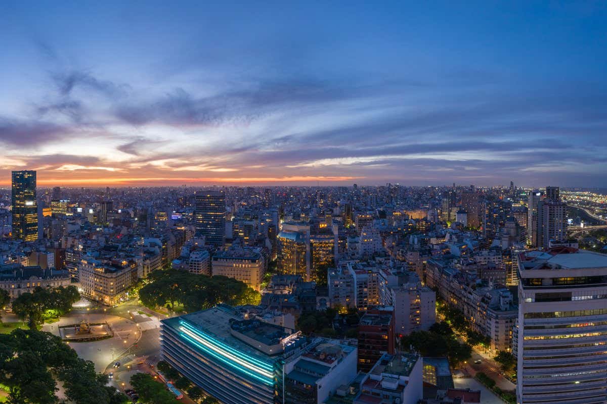 Vista panorámica aérea del skyline de Buenos Aires al atardecer con las luces de la ciudad encendidas