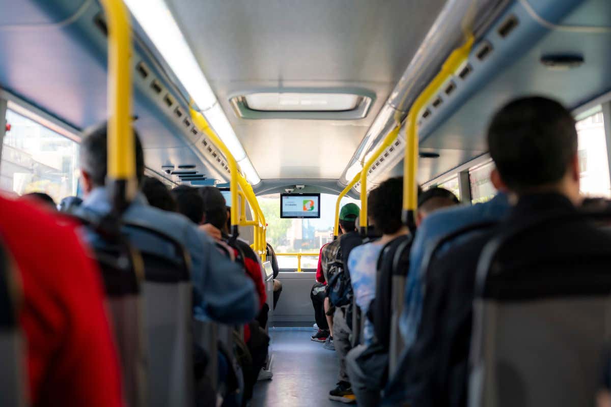 Varias personas sentadas en el interior de un autobús urbano
