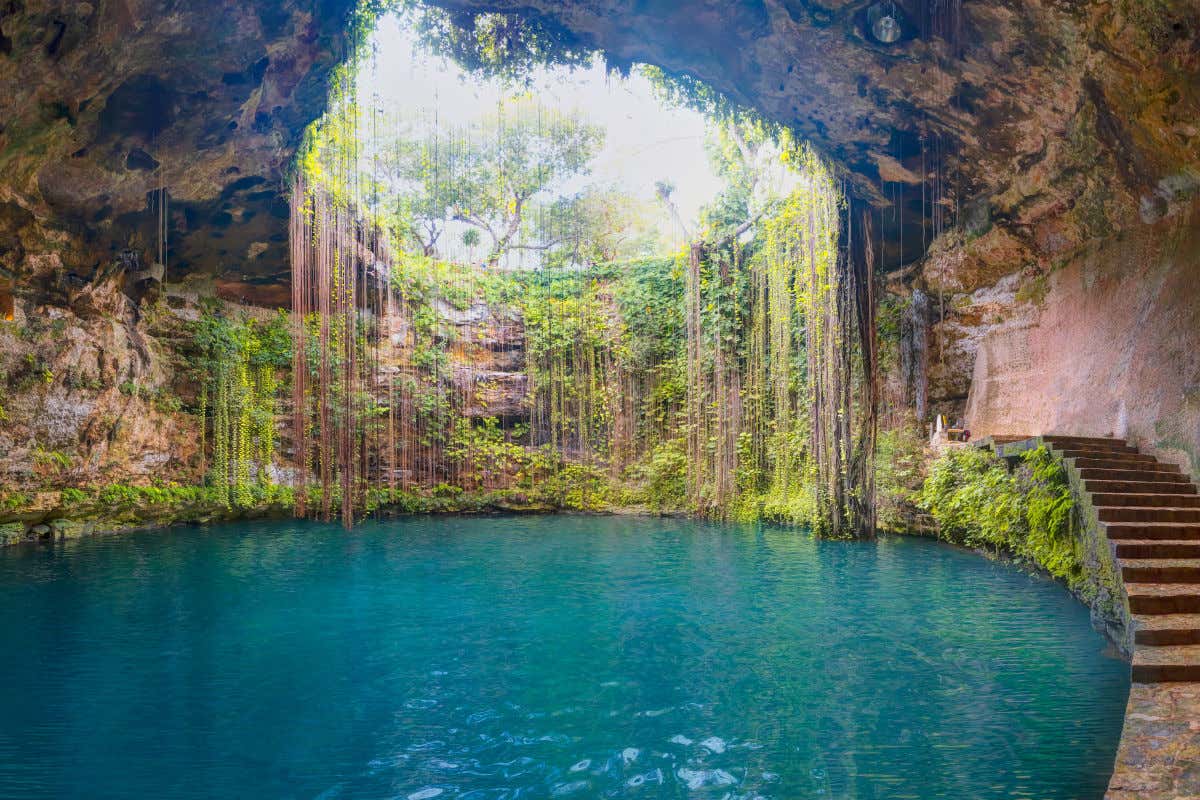El cenote Ik Kil, una superficie de agua turquesa en el interior de una cueva pero con una gran cavidad que permite ver la vegetación del exterior