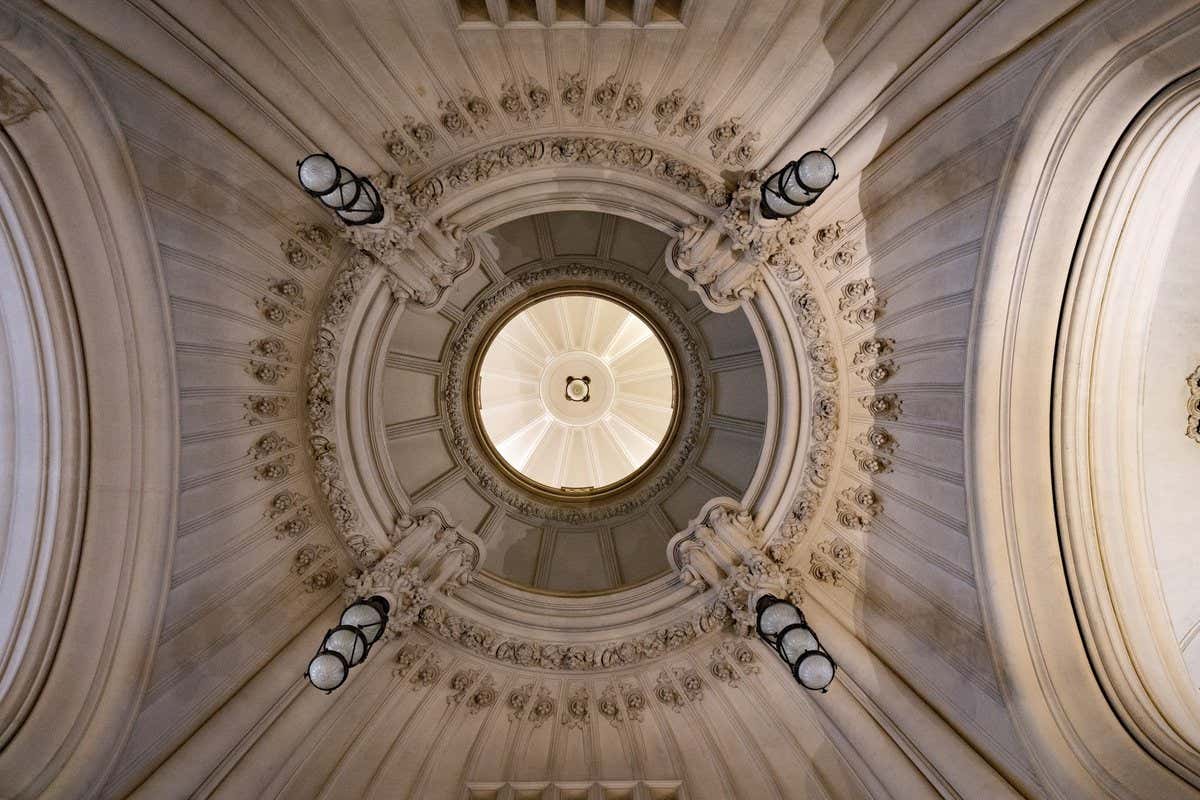 Vista desde abajo de una cúpula ornamentada con detalles clásicos en un edificio histórico de Buenos Aires