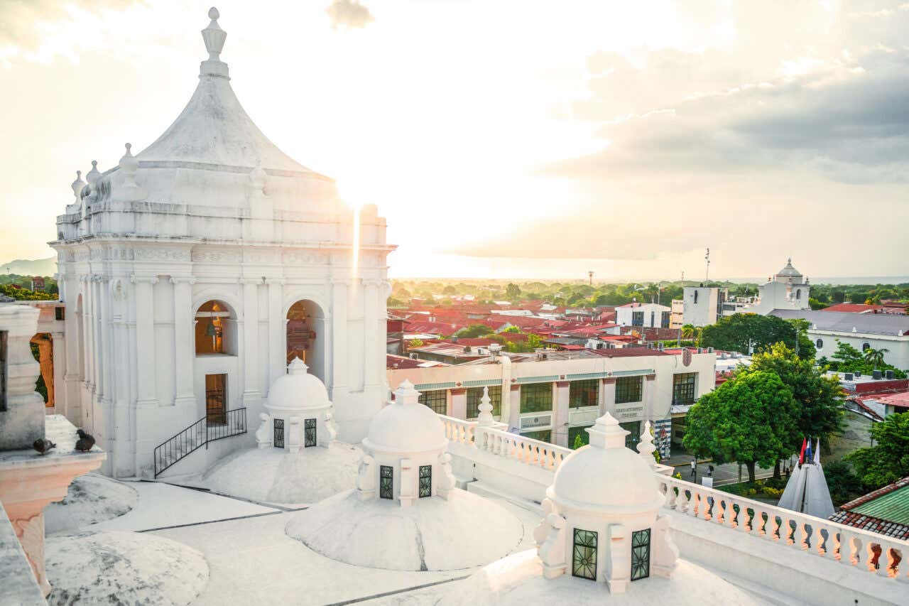 Vista de las cúpulas blancas de la Catedral de León con la ciudad de fondo al atardecer