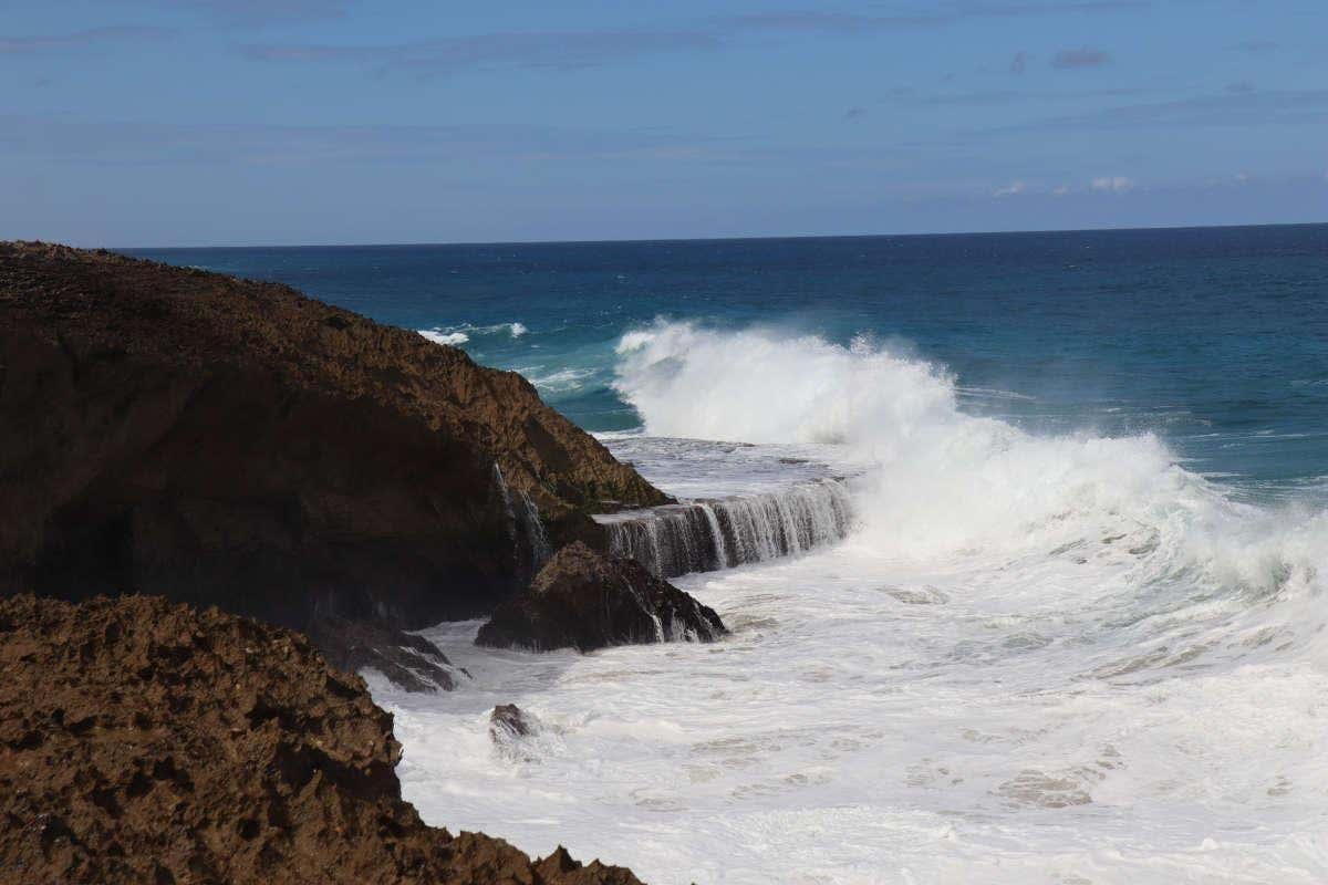 Olas rompiendo contra unos acantilados de una playa de Puerto Rico