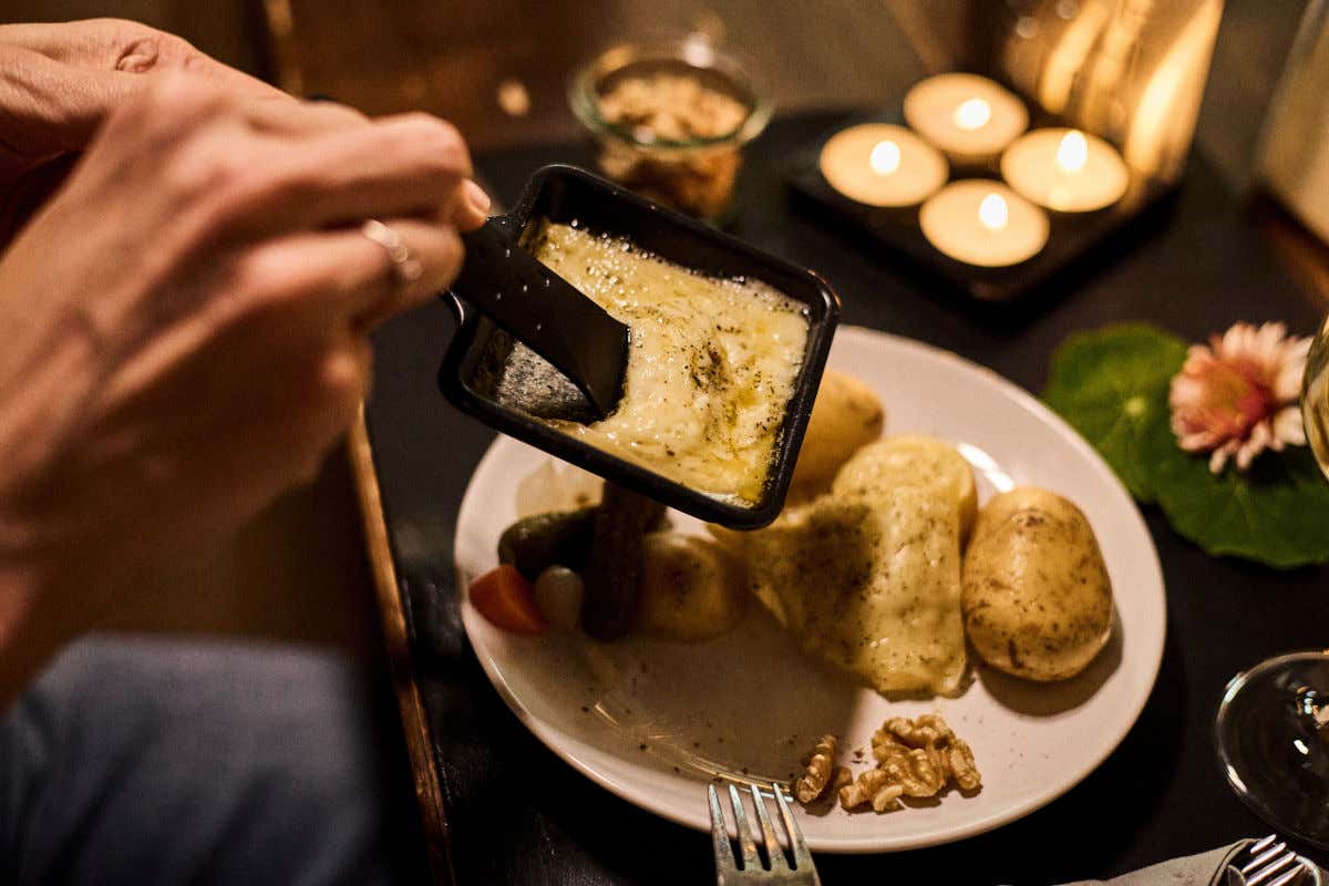 Una raclette suiza, es decir, queso fundido que se vierte directamente sobre un plato de guarniciones como verduras y patatas