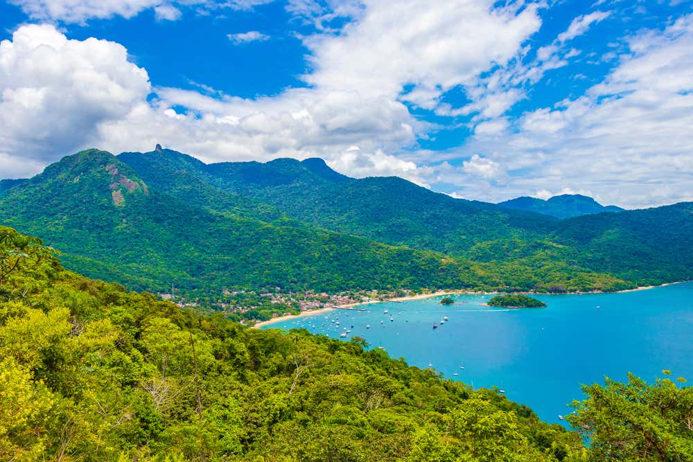 Vista aérea da Praia do Abraão, em Ilha Grande, Angra dos Reis, Rio de Janeiro, Brasil, com o mar cercado pela exuberante vegetação tropical