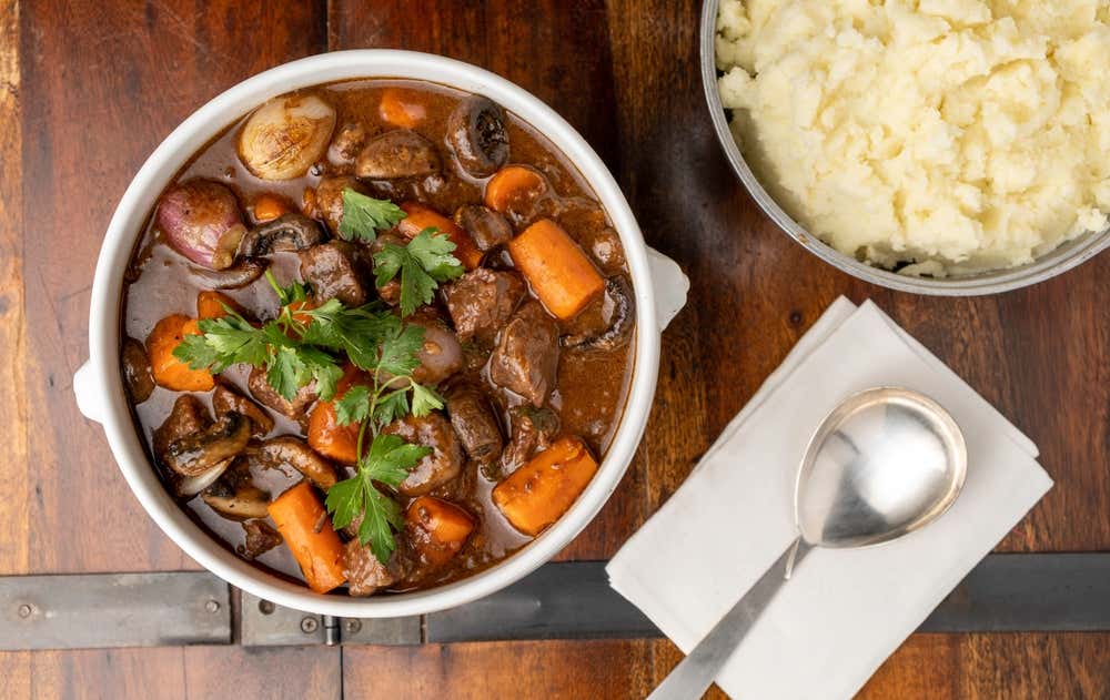 Boeuf bourguignon, clássico da culinária francesa, preparado com carne bovina cozida lentamente em vinho tinto e legumes