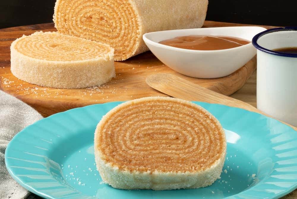 Detalhe de um bolo de rolo em um prato azul