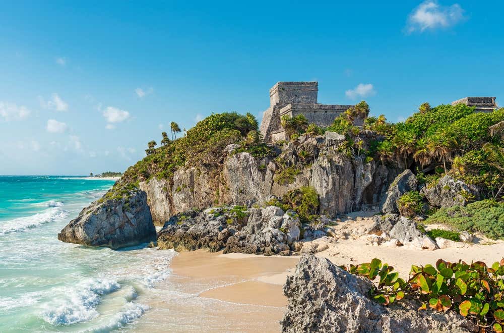 Tulum, Quintana Roo seen from afar, with a temple sitting on the cliffside.