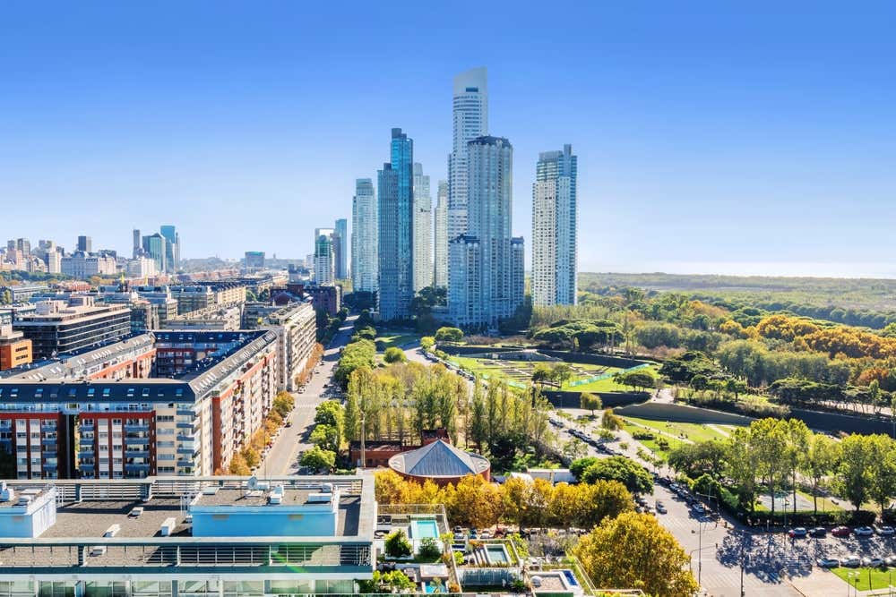 Vista de Puerto Madero em um dia ensolarado, com sua arquitetura moderna, calçadão à beira do rio e arranha-céus, em Buenos Aires, Argentina