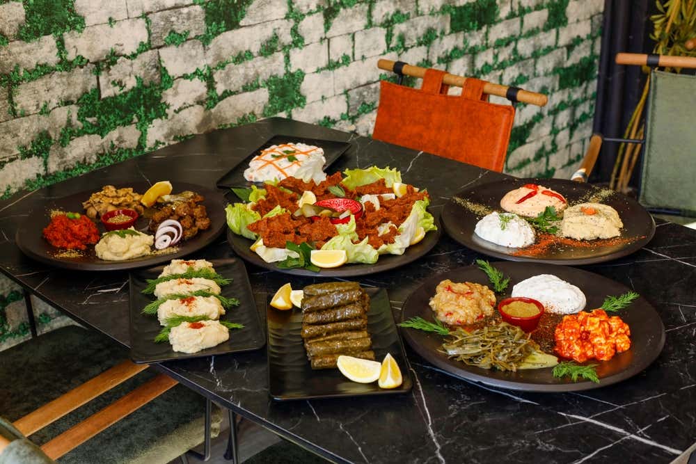Uma mesa com pratos tradicionais da culinária turca, com diferentes opções de recheios, saladas e aperitivos