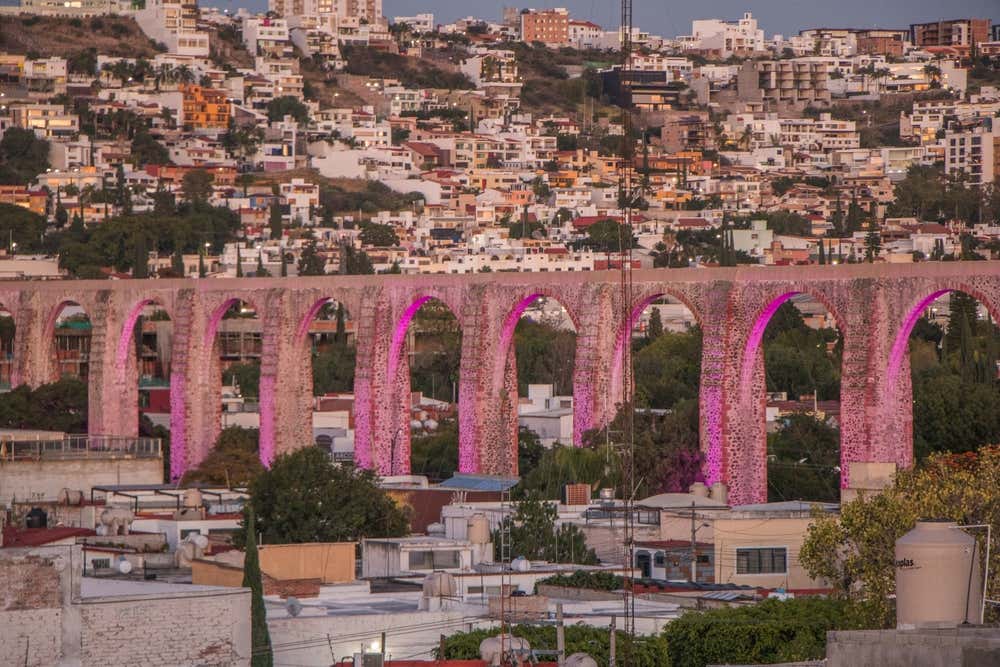 Los Arcos de Querétaro lit up in pink light in the city.