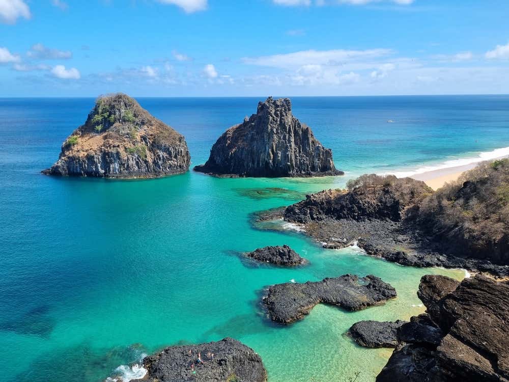 Morro Dois Irmãos visto da Baía dos Porcos, em Fernando de Noronha, Pernambuco, Brasil, com águas cristalinas, formações rochosas e uma das paisagens mais icônicas do arquipélago