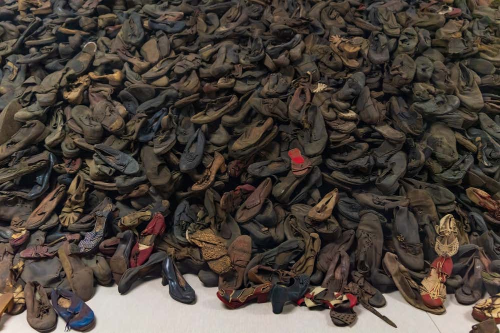 Enorme mucchio di migliaia di scarpe usate e logore di vittime dell'Olocausto, conservate ed esposte come memoriale all'interno del Museo Statale di Auschwitz-Birkenau