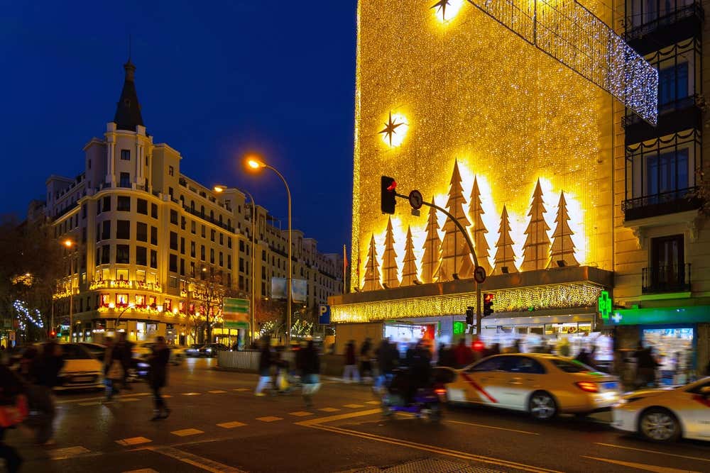 Decoração de Natal na área comercial de Madrid ao anoitecer, com luzes festivas que criam um ambiente acolhedor e encantador
