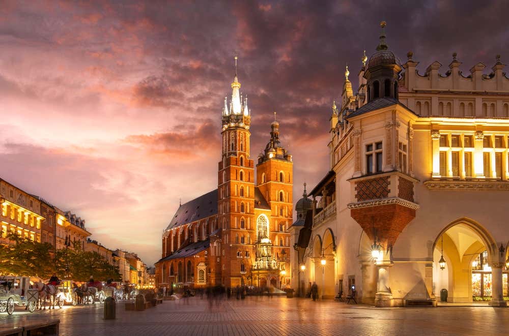 Basílica de Santa Maria (Igreja de Mariacki) no centro histórico de Cracóvia, na Polônia. Iluminada na praça principal do mercado à noite, após o pôr do sol