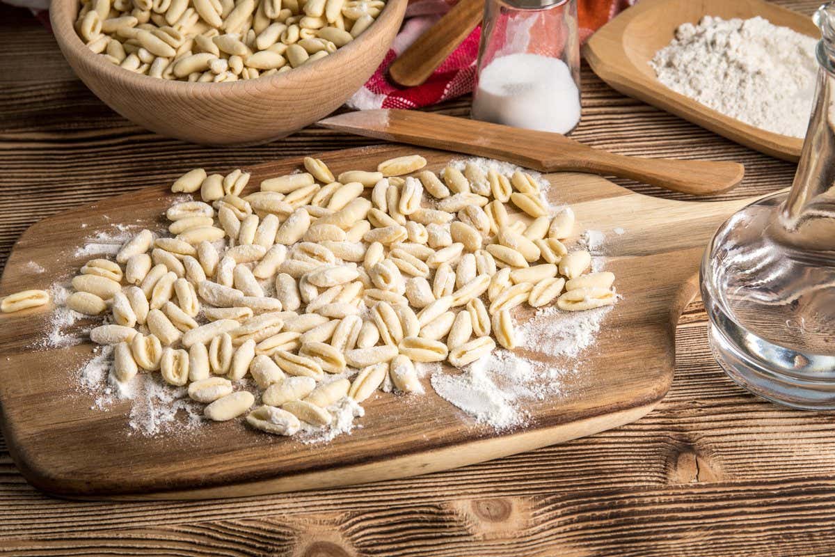 Cavatelli de pasta fresca casera espolvoreados con harina sobre una tabla de madera