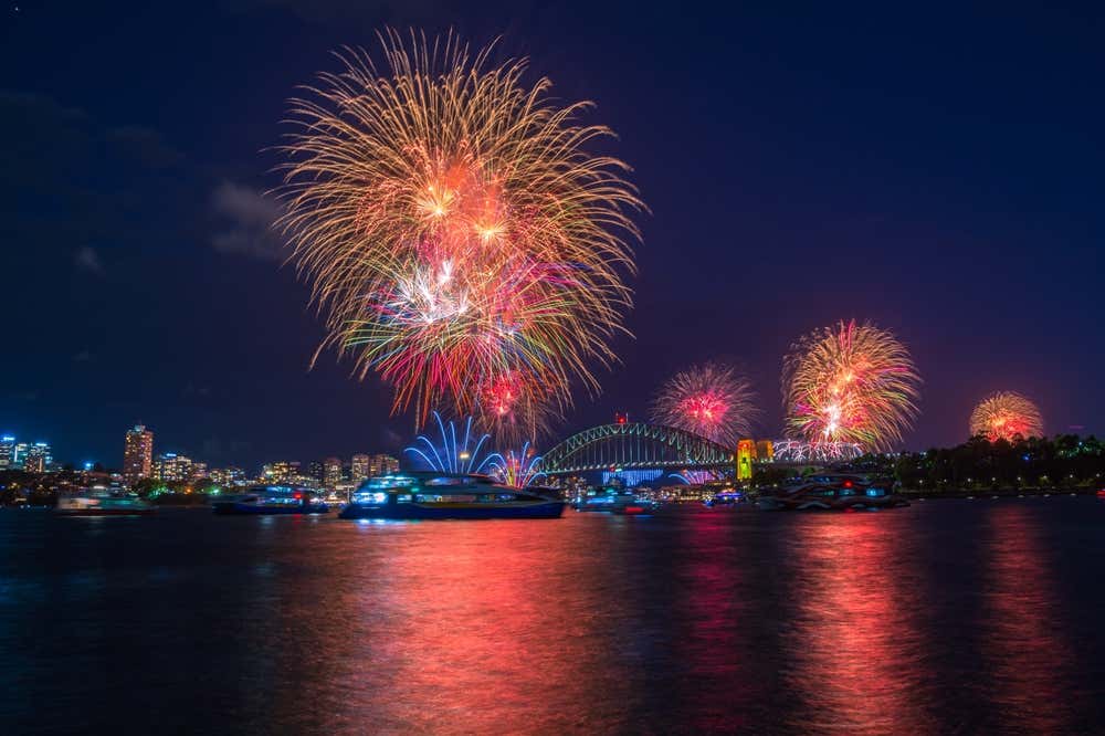 Fogos de artifício coloridos iluminando o céu de Sydney durante a celebração da véspera de Ano-Novo, na Austrália