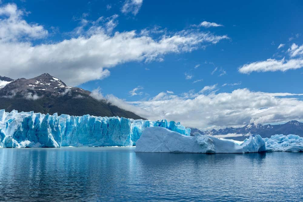 Vista da geleira Perito Moreno em uma manhã enevoada e chuvosa, com suas imponentes paredes de gelo cercadas pela paisagem montanhosa da Patagônia argentina