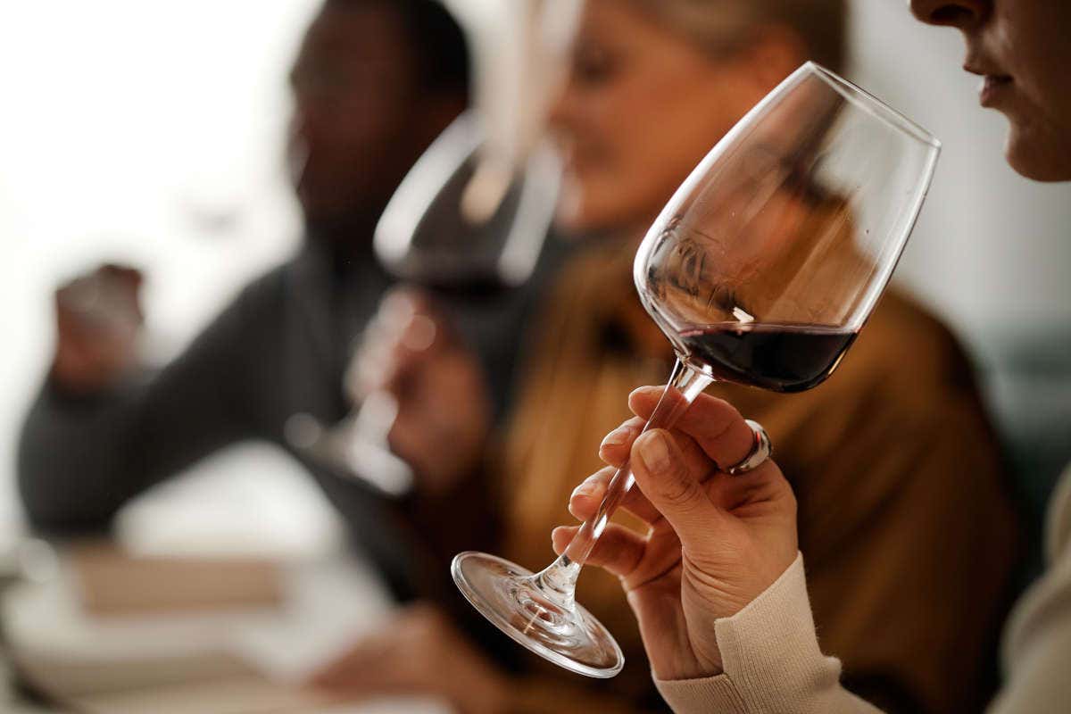 Una mujer catando una copa de vino tinto