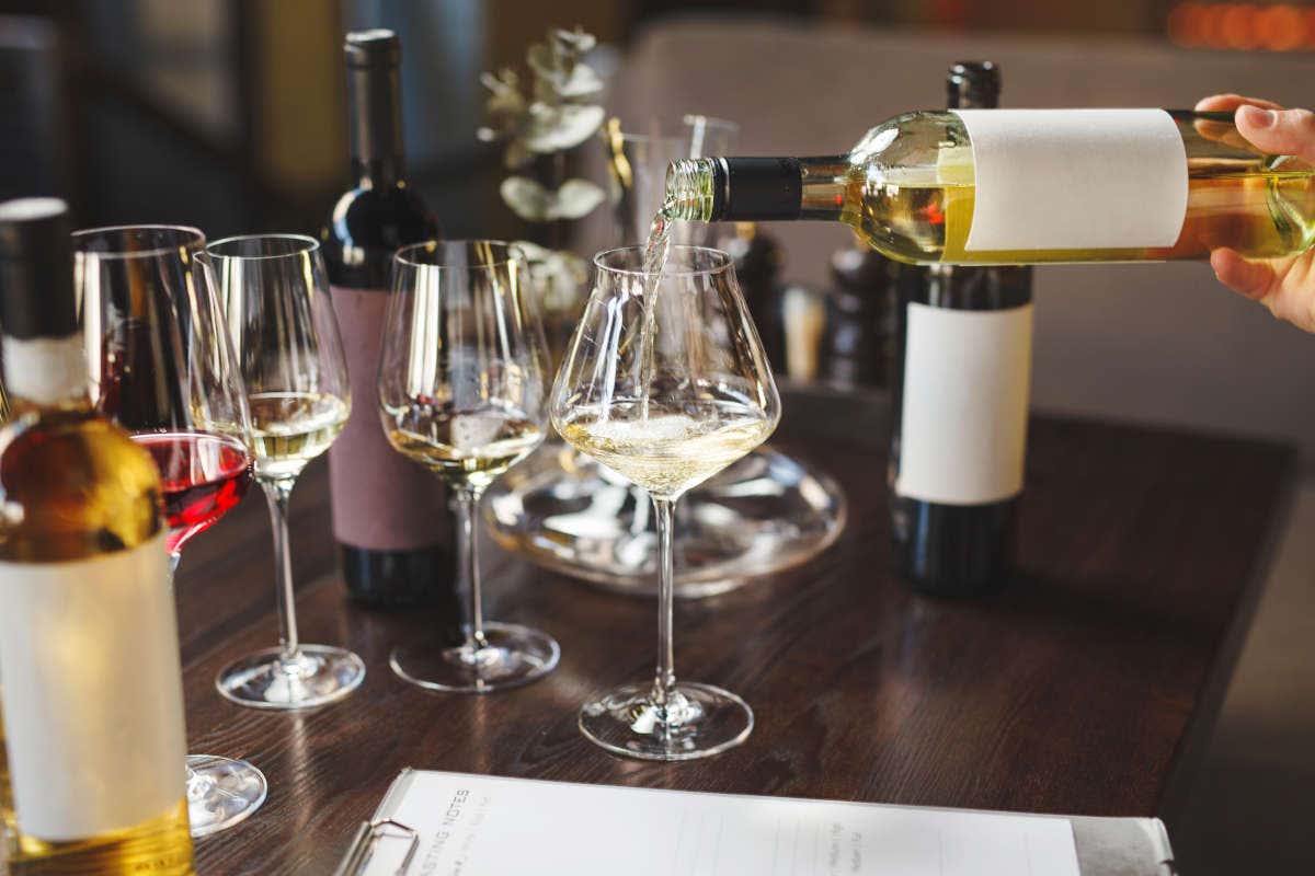 Sirvendo copas de vino blanco durante una cata de vino
