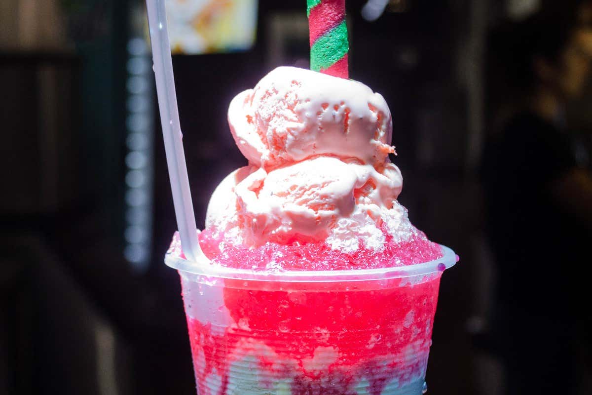 Granizado de fresa con bolas de helado y barquillo de colores en vaso grande