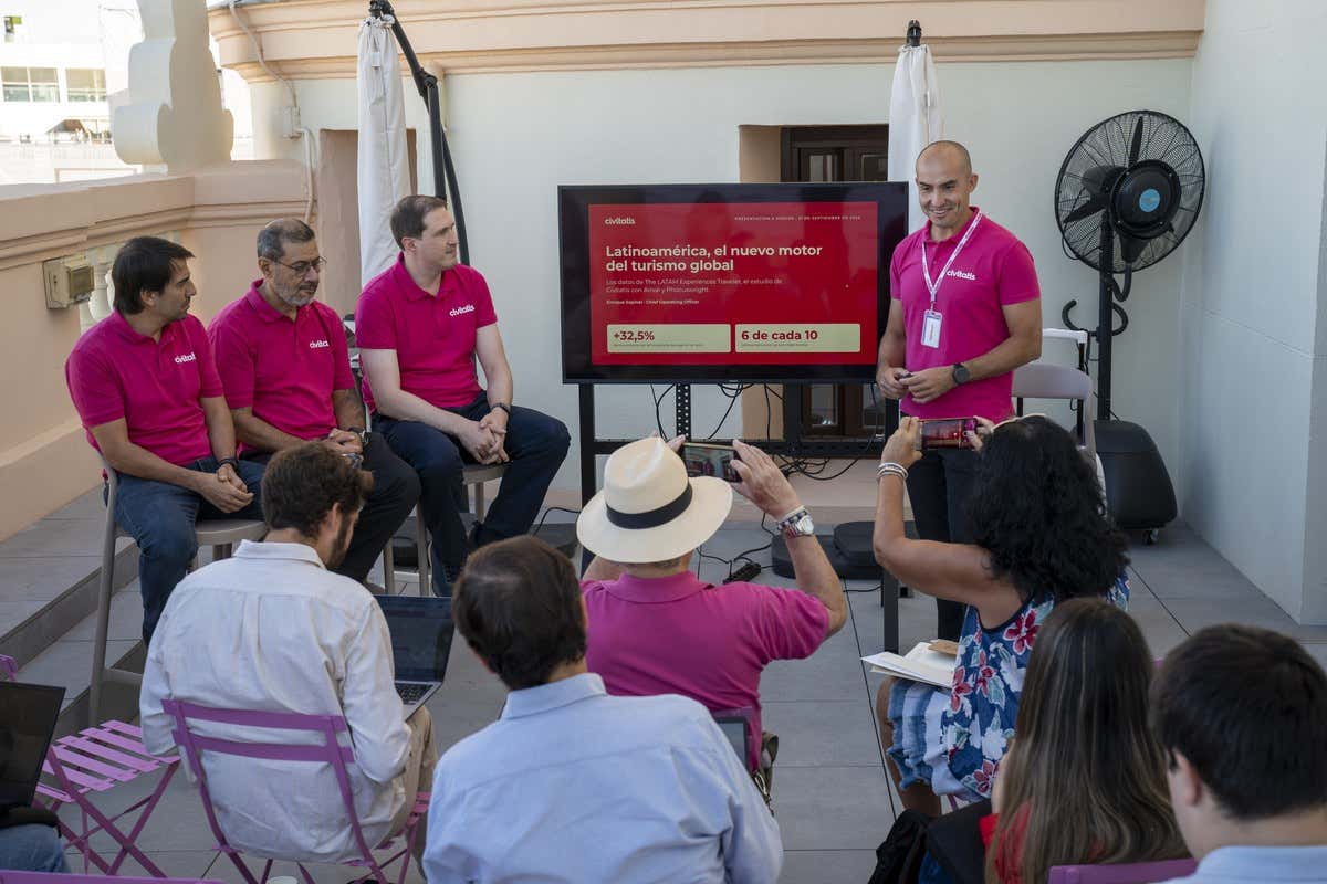Enrique Espinel, COO de Civitatis, con polo rosa explicando datos a un grupo de periodistas en una terraza