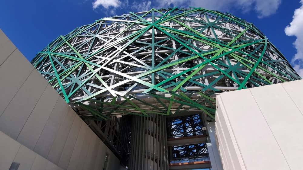 Gran Museo del Mundo Maya seen from below with a blue cloudy sky in the background.