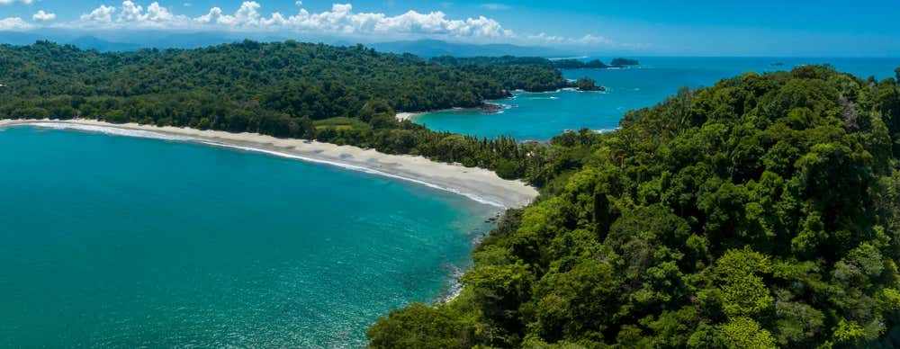 Vista aérea do Parque Nacional Manuel Antonio, na Costa Rica, com suas áreas de floresta tropical e paisagens costeiras cercadas pelo Oceano Pacífico