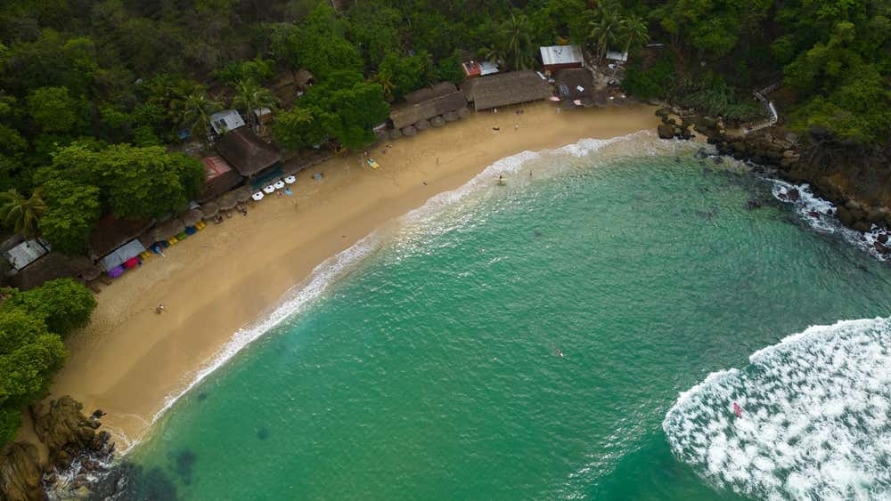 Playa Carrizalillo vista desde arriba con algunos edificios detrás de la playa
