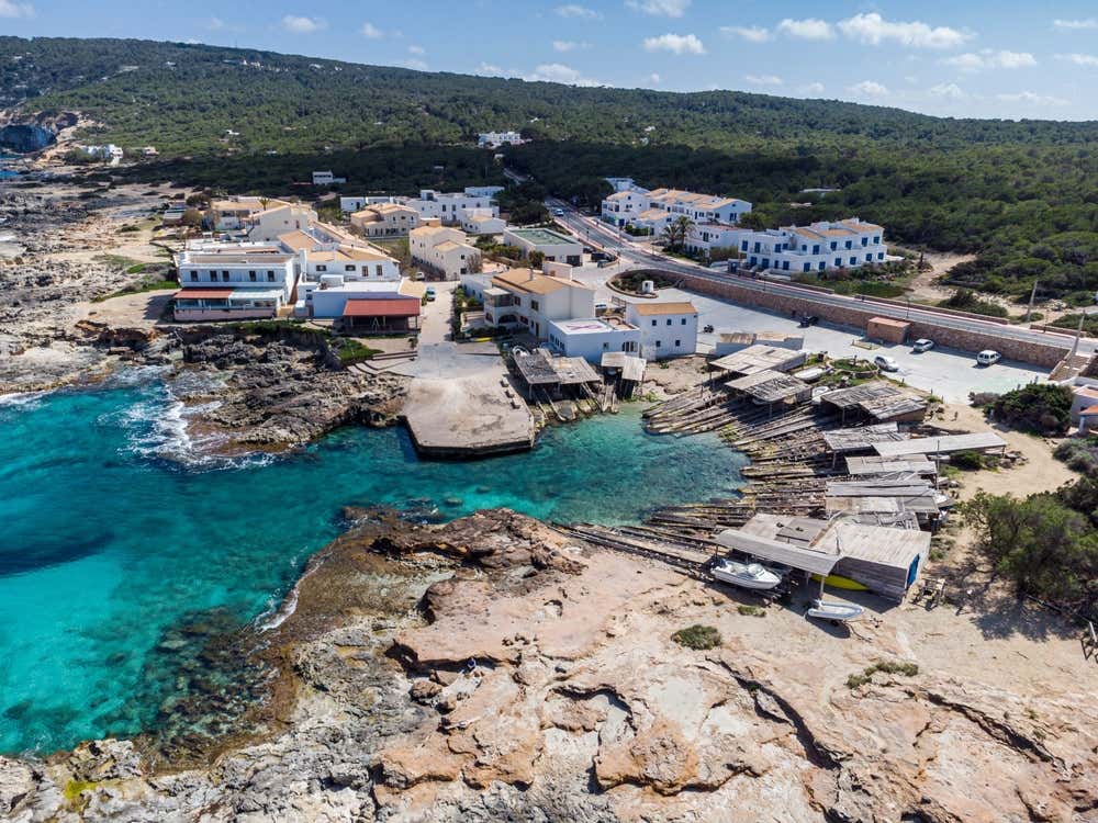 Es Caló de Sant Agustí, na costa de Tramuntana, em Formentera, nas Ilhas Baleares, Espanha, com suas tradicionais construções de madeira junto ao mar e as águas cristalinas do Mediterrâneo