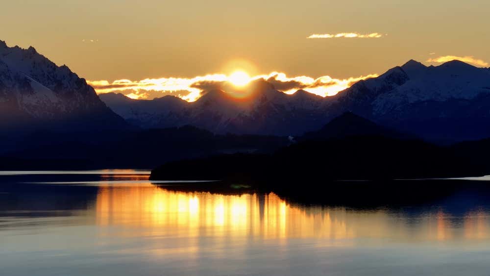 Pôr do sol sobre a baía de San Carlos de Bariloche, com as águas do Lago Nahuel Huapi e as montanhas da Patagônia ao fundo