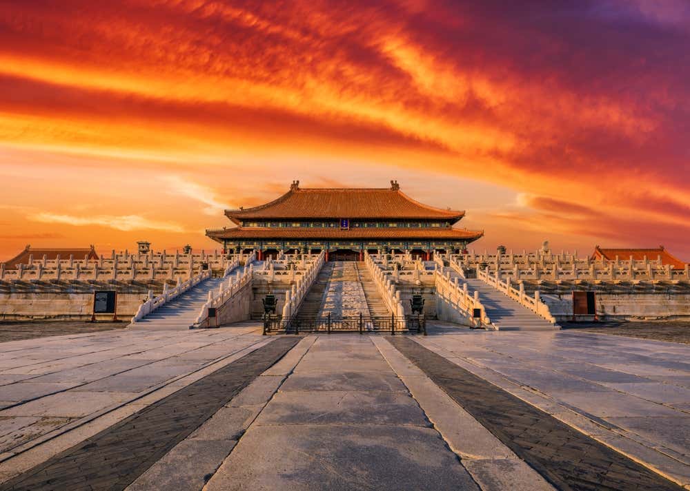 Majestosa Cidade Proibida ao pôr do sol, com seus palácios e telhados tradicionais diante de um céu vibrante, em Pequim, China