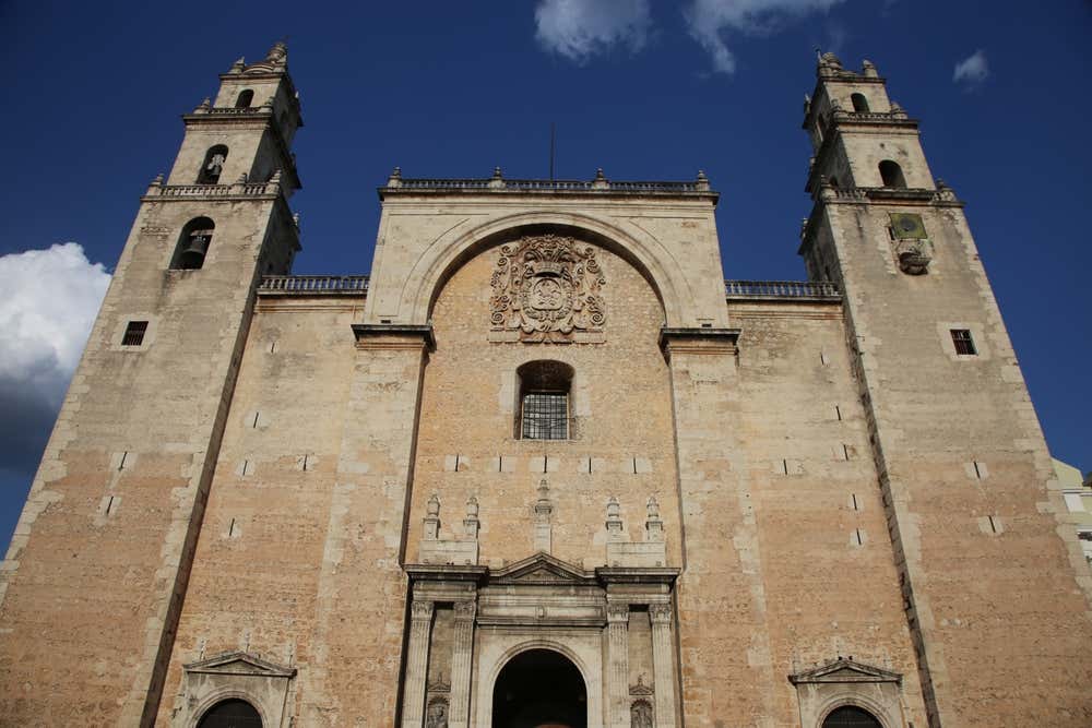 Merida Cathedral seen from below with a slightly cloudy sky in the background.