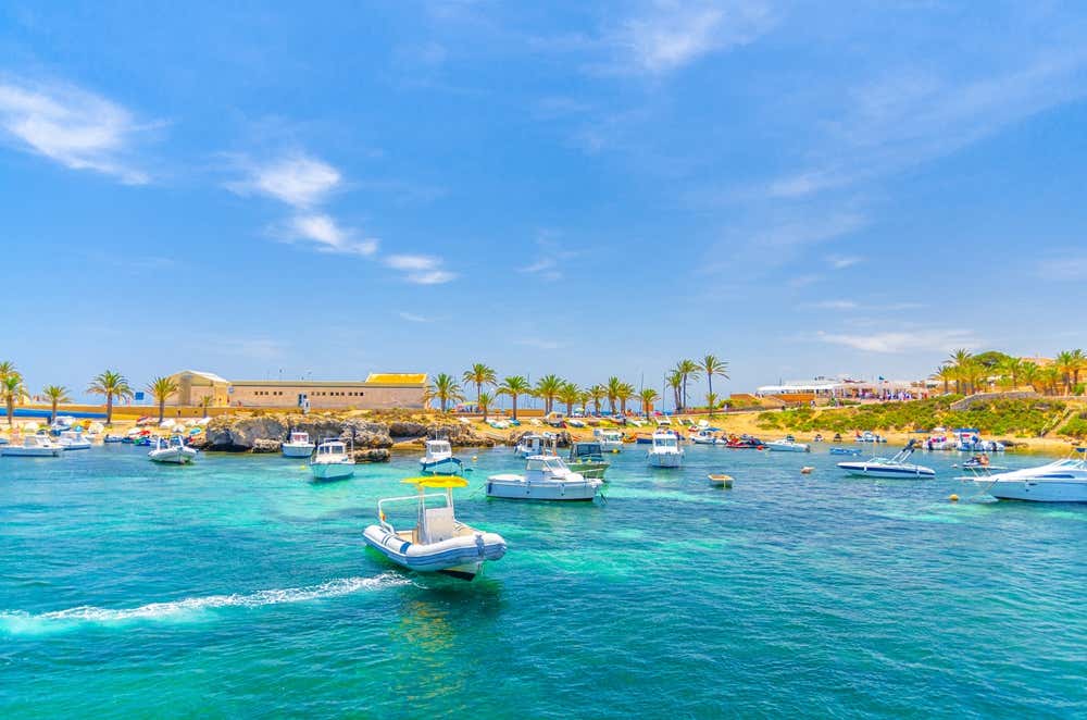 Iates e lanchas ancorados nas águas da baía de Alicante, próximo à costa da ilha de Tabarca, na província de Alicante, Espanha, em um dia ensolarado de verão
