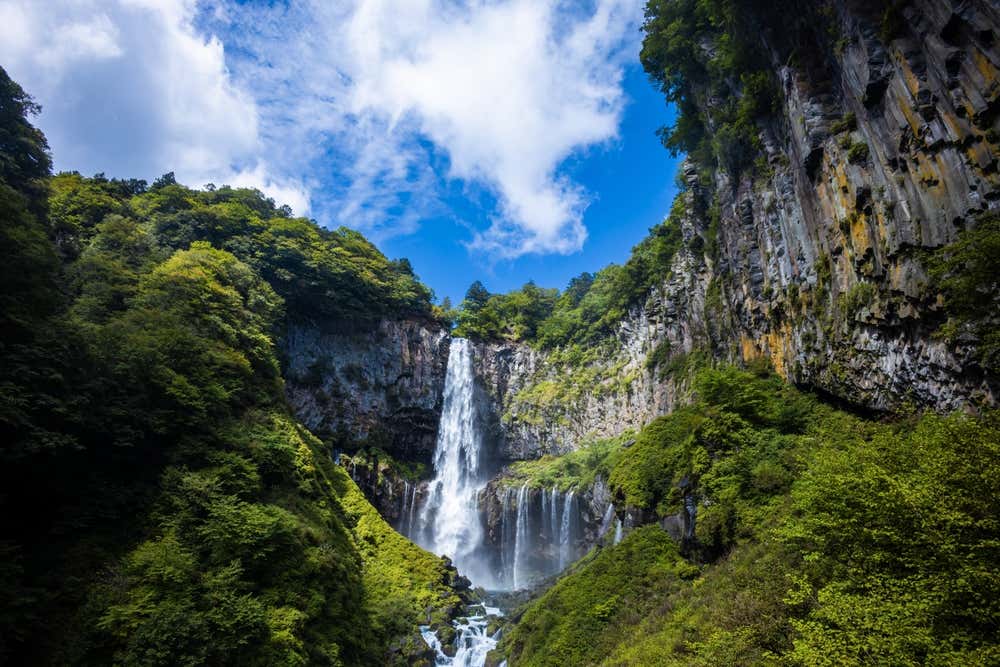 Kegon Falls, Niko seen from below with a cloudy sky above.