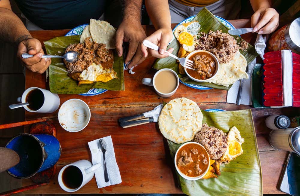 Gallo Pinto in costa rica served to various people on a banana leaf with coffee.