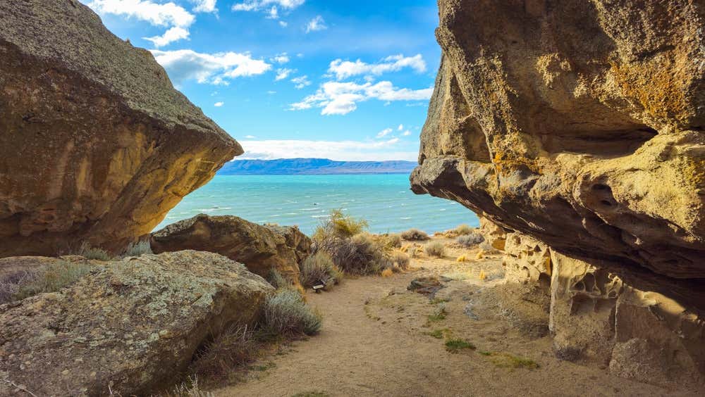 Águas turquesa do Lago Argentino junto às formações rochosas e grutas de Punta Walichu, na Patagônia argentina