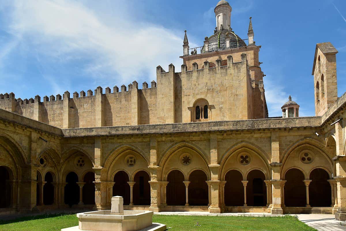 Claustro românico-gótico da Sé Velha de Coimbra com ameias e cúpula ao fundo