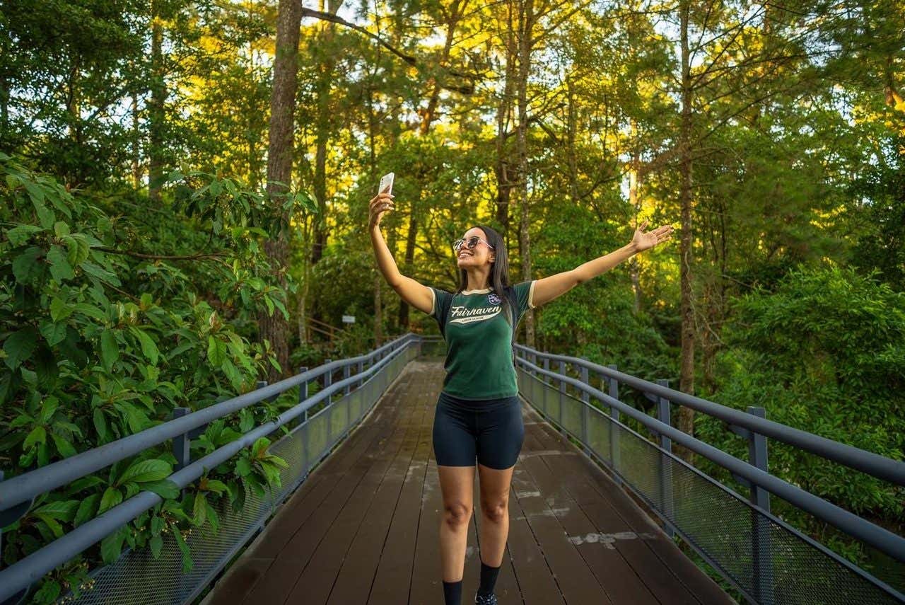 Una chica haciéndose un selfie en mitad del bosque