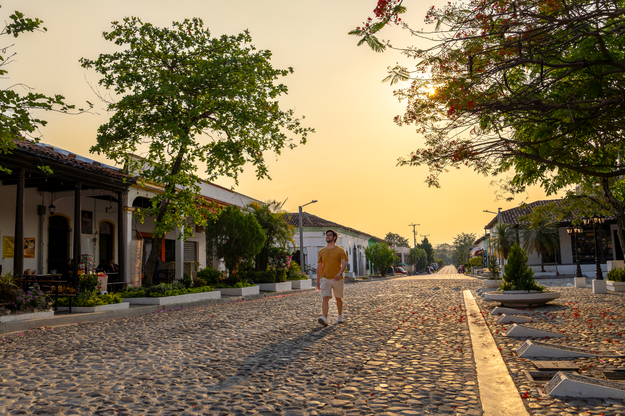 Un chico caminando por las calles empedradas de Suchitoto al atardecer