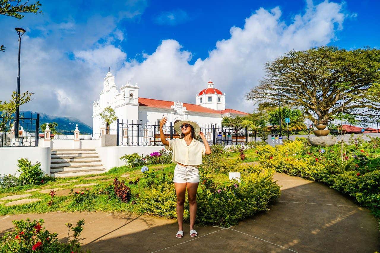 Una chica haciéndose un selfie ante la iglesia de Nahuizalco