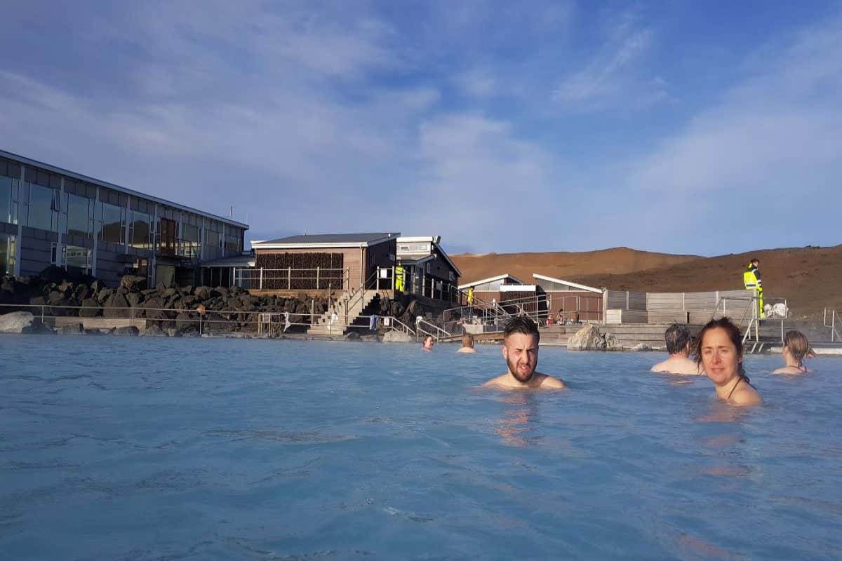 Un hombre y una mujer con otras personas en un baños de Mývatn en Islandia.
