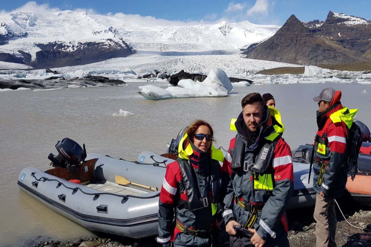 Un grupo de personas junto a un barco en la laguna glaciar Fjallsárlón.