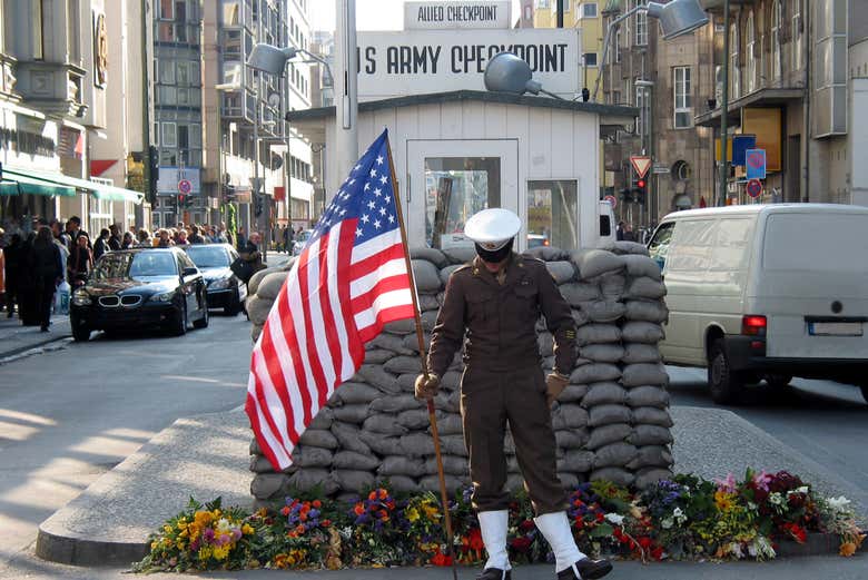 Soldado con bandera de EEUU en el Checkpoint Charlie de Berlín