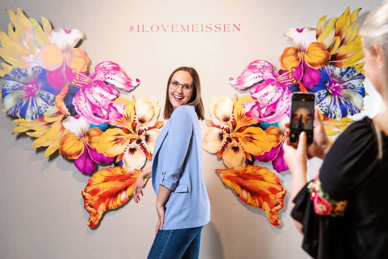 Una ragazza in posa davanti al murales di Meissen