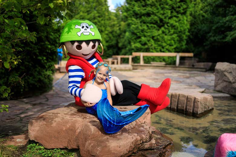 Una bambina con un animatore del parco