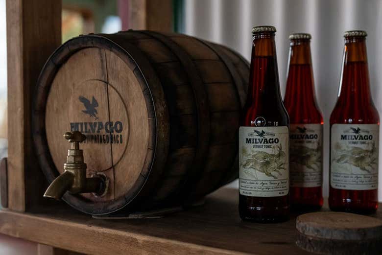 Bouteilles de vermouth à côté d'un tonneau