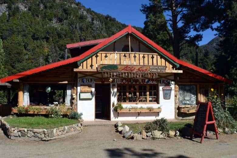 See the wooden house in Colonia Suiza